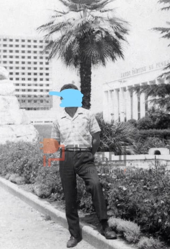 3. Pa mbaruar ende mirë, populli vërshoi të bënte një foto duke patur në sfond 15 katëshin.Një banor i Tiranës duke pozuar në lulishten pas monumentit të Skënderbeut dhe në sfond është hotel Tirana ende e pambaruar.