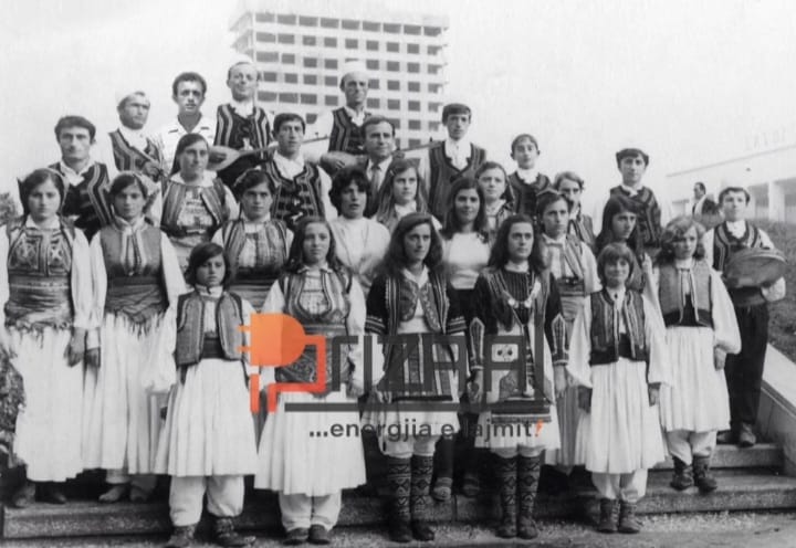 4. Sfondin e 15 katëshit nuk e kishin pronësi vetëm banorët e Tiranës. Në këtë fotografiështë një grup artistik nga veriu që ka pozuar me sfond 15 katëshin ende të pambaruar.