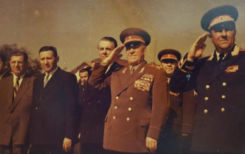 Foto 1: 15 tetor 1957. Në qendër duke nderuar ushtarakisht, Georgi Zhukov, ministër i Mbrojtjes së Bashkimit Sovjetik, së bashku me Enver Hoxhën, kryeministrin Mehmet Shehu, ministrin e Mbrojtjes Beqir Balluku dhe personalitete të tjera.